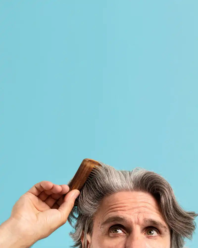 Homme peignant des cheveux gris.